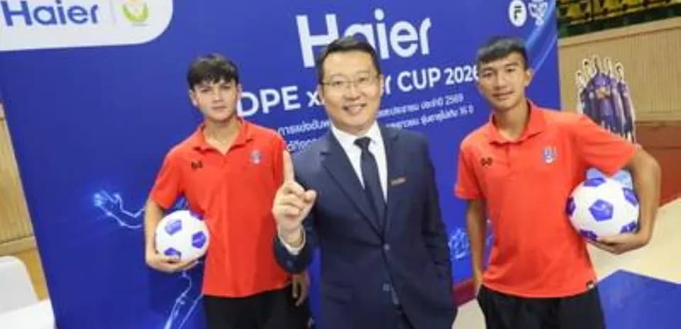 Two young football players with a representative at event