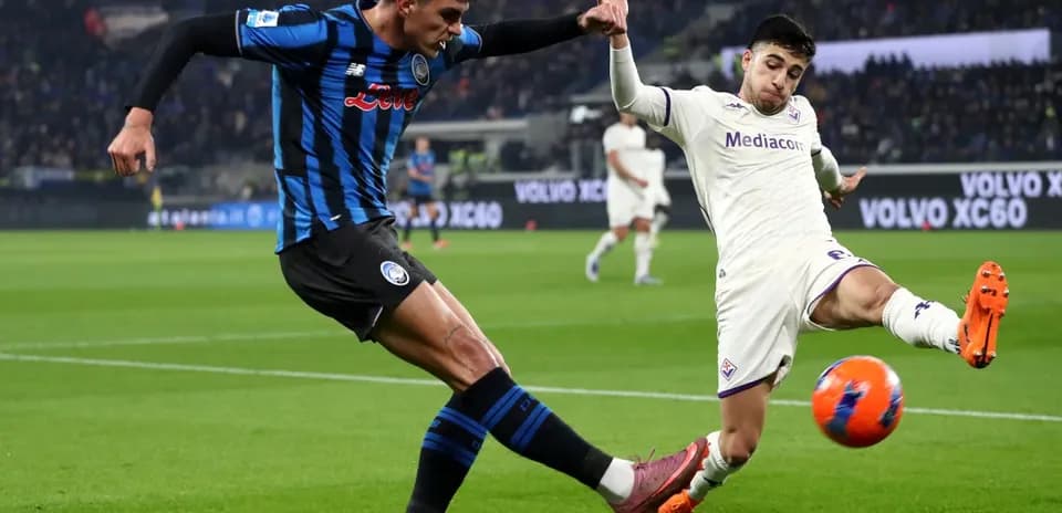 Fiorentina player challenging Atalanta opponent for ball