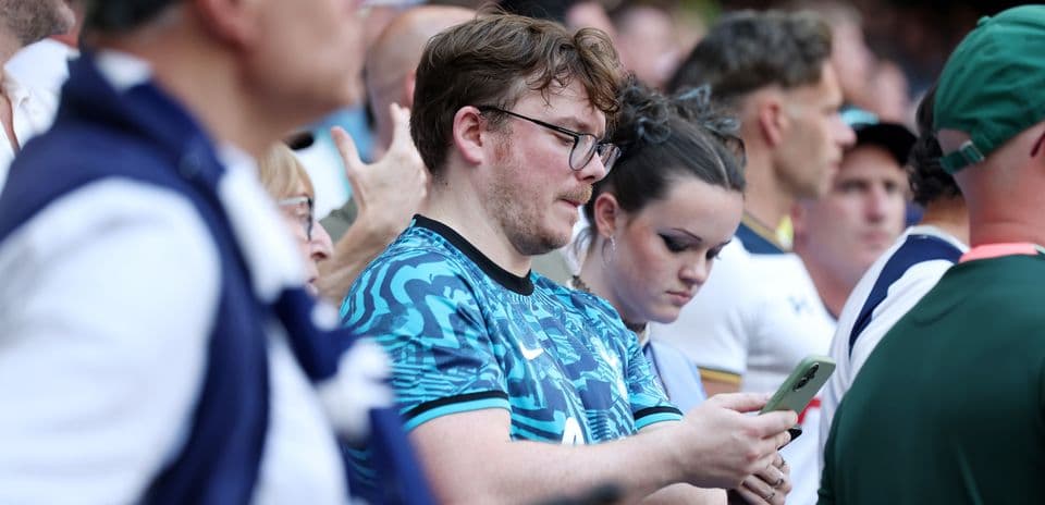 Fans watching the match and using their phones