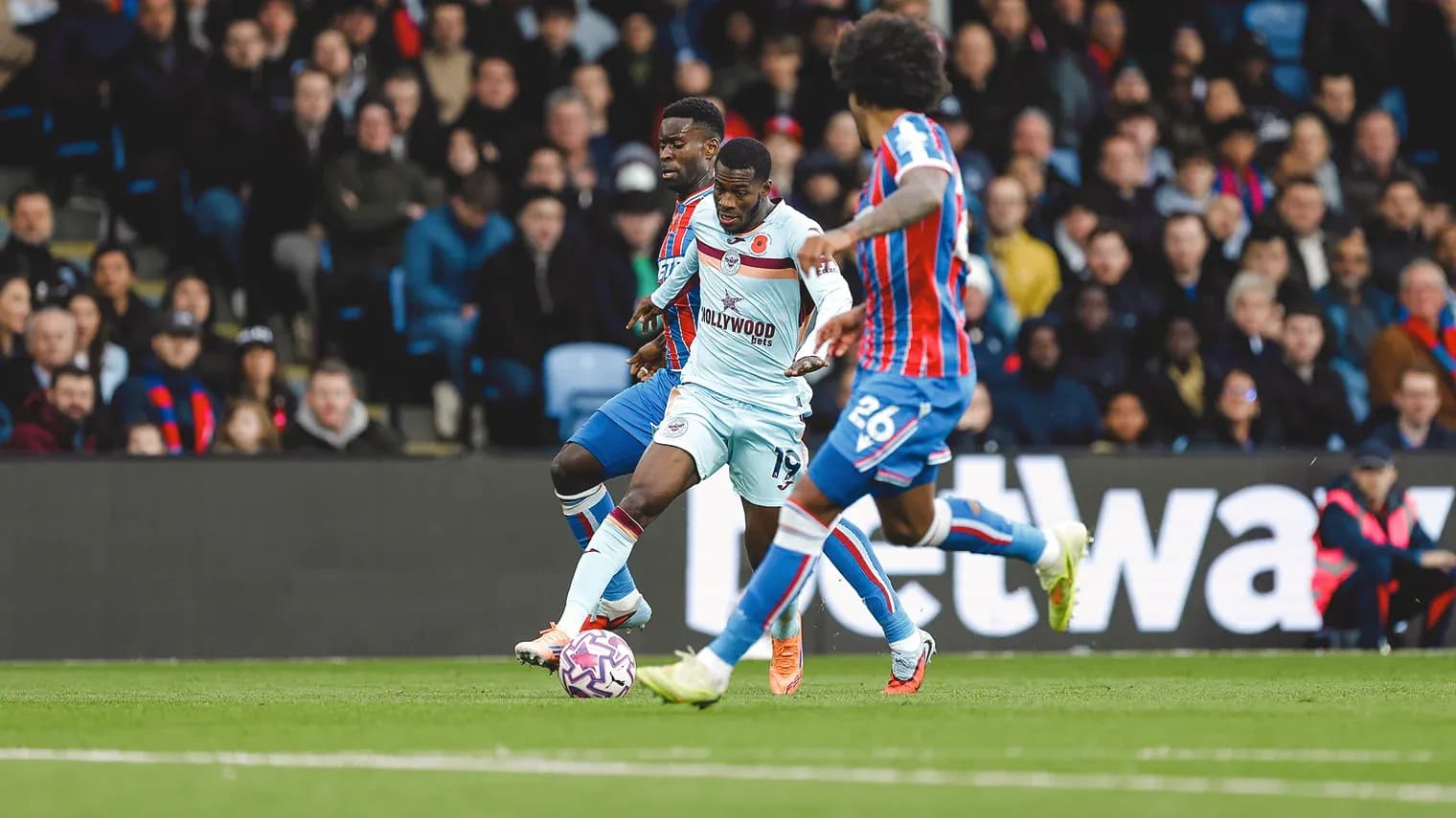 Brentford player dribbling past Crystal Palace defenders