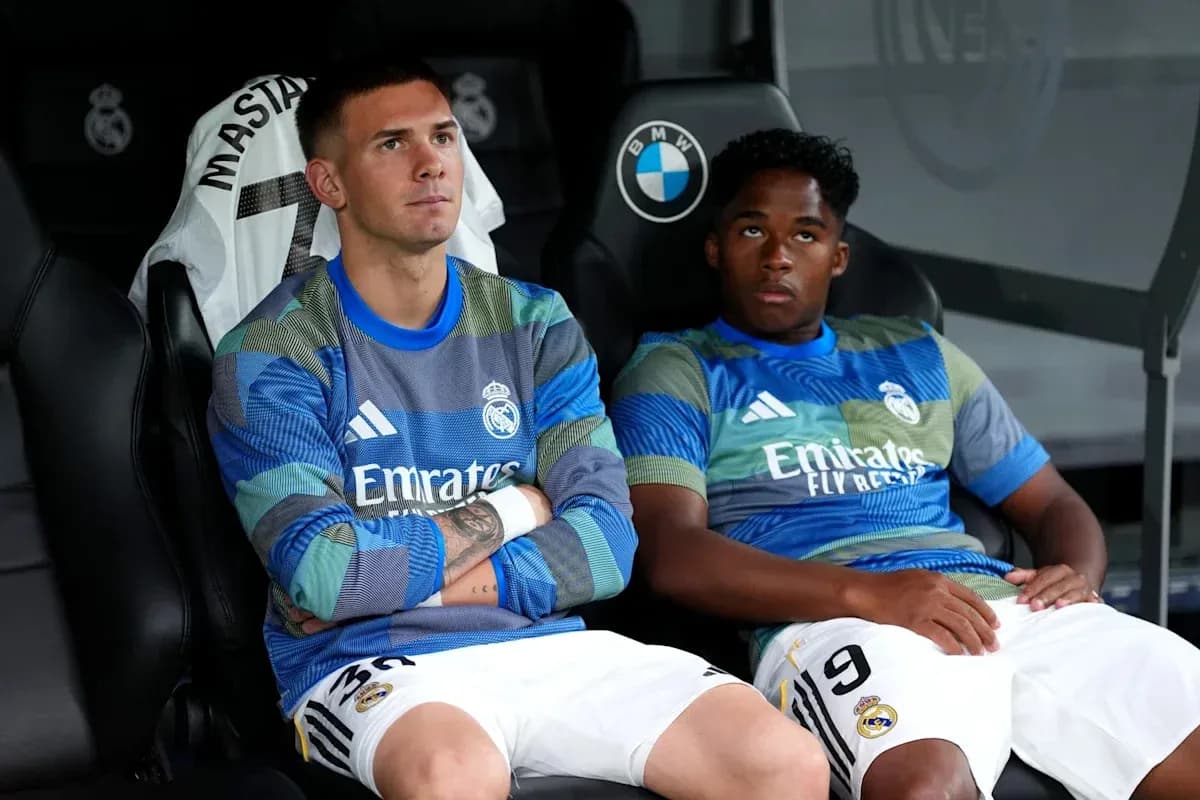 Two Real Madrid players seated on bench during match