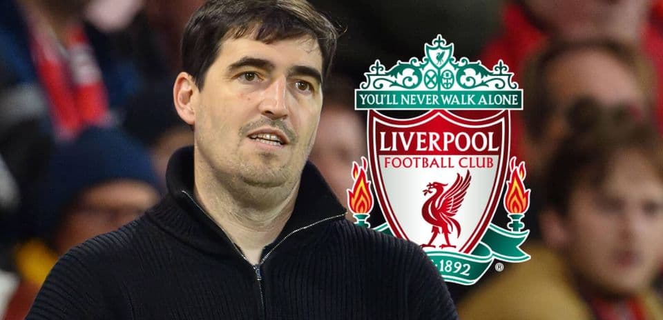 Person standing in front of Liverpool FC logo