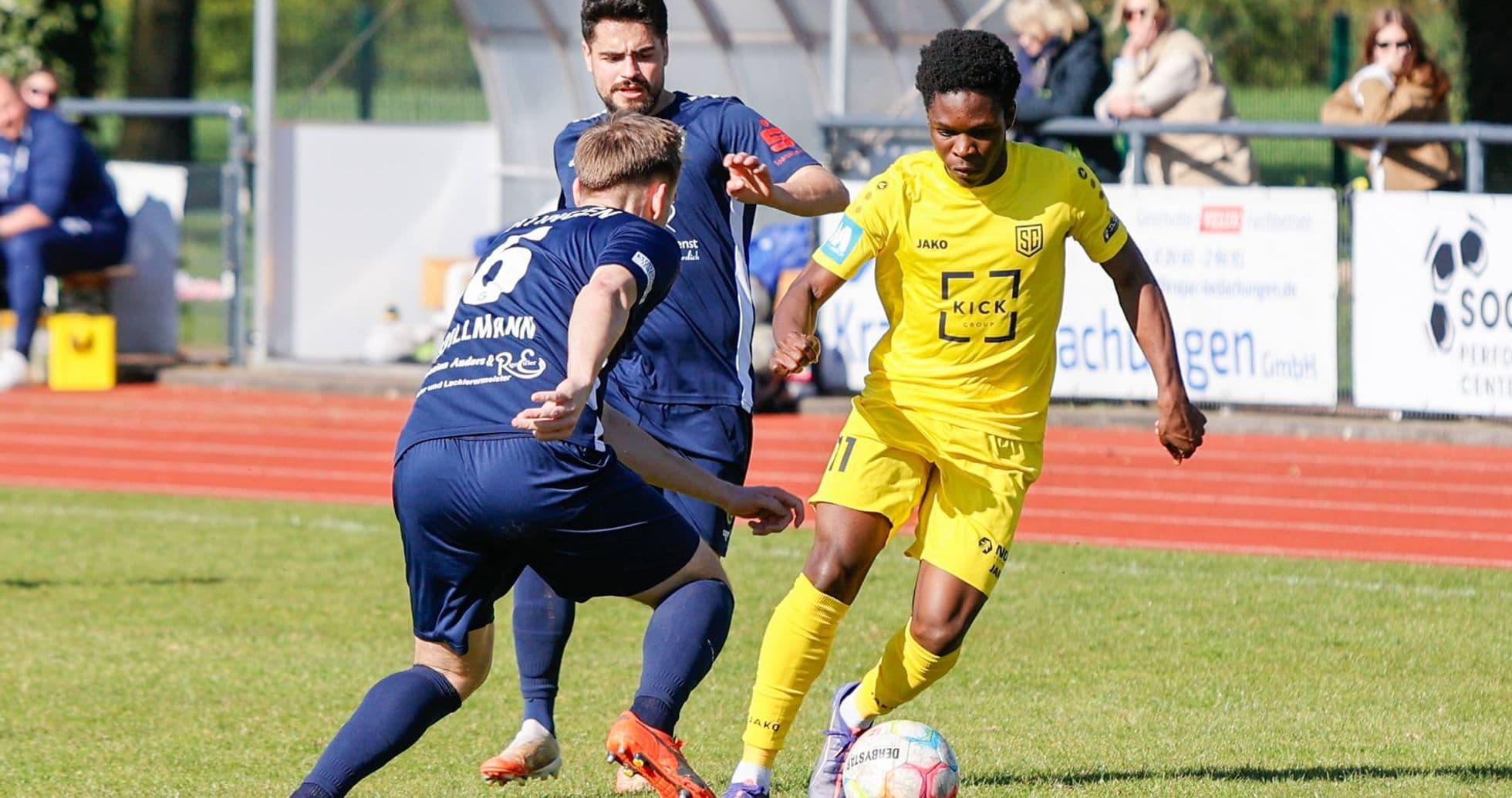 Player in yellow dribbling past opponent in blue