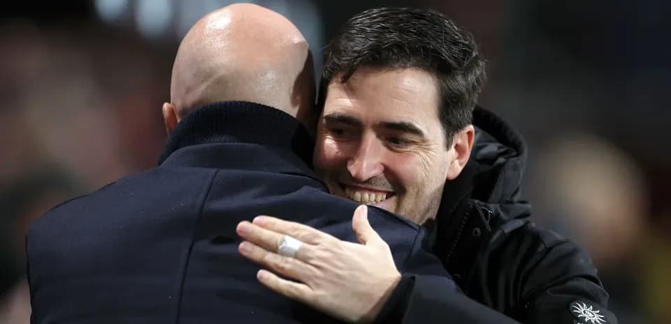 Two coaches embracing after a match