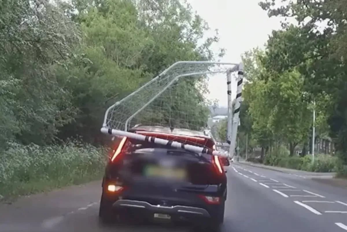 Car transporting a soccer goal on its roof