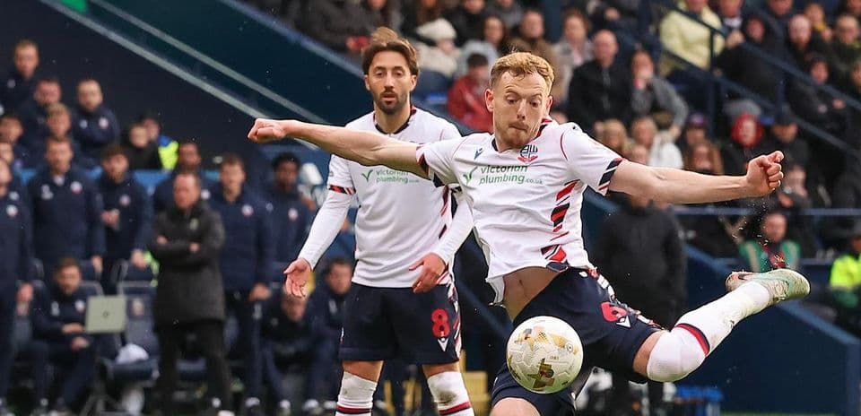 Bolton player kicking ball during match action