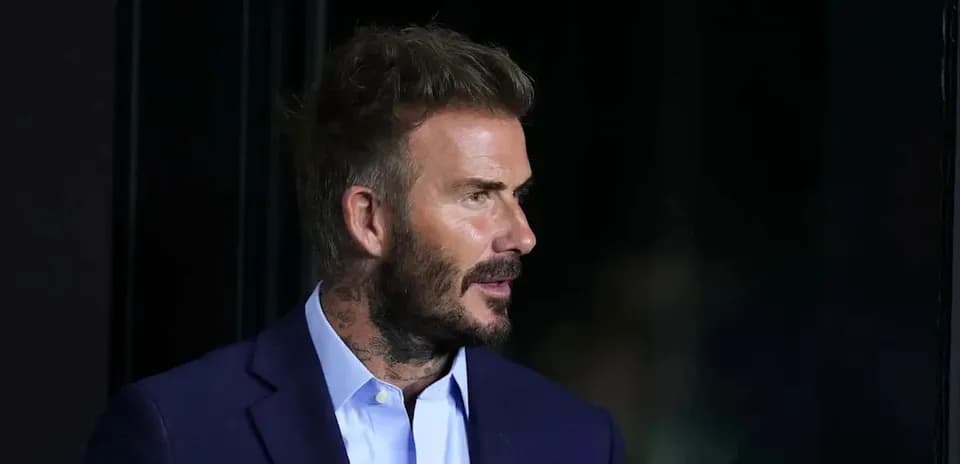 Profile of a man in a suit with tattoos