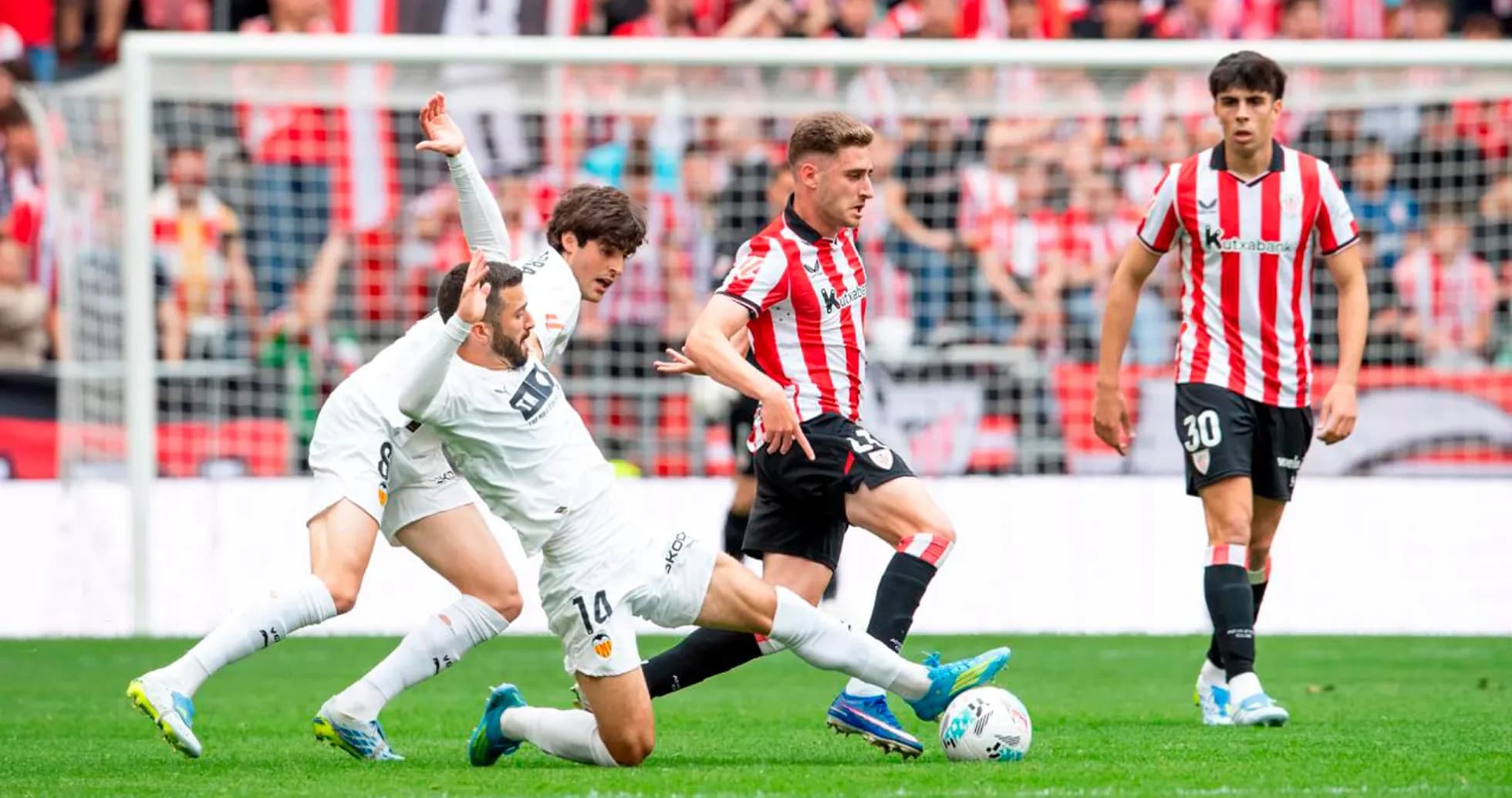 Athletic Club player challenges Valencia opponent for ball