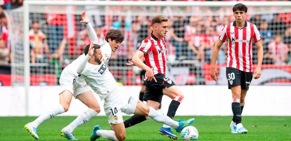 Athletic Club player challenges Valencia opponent for ball