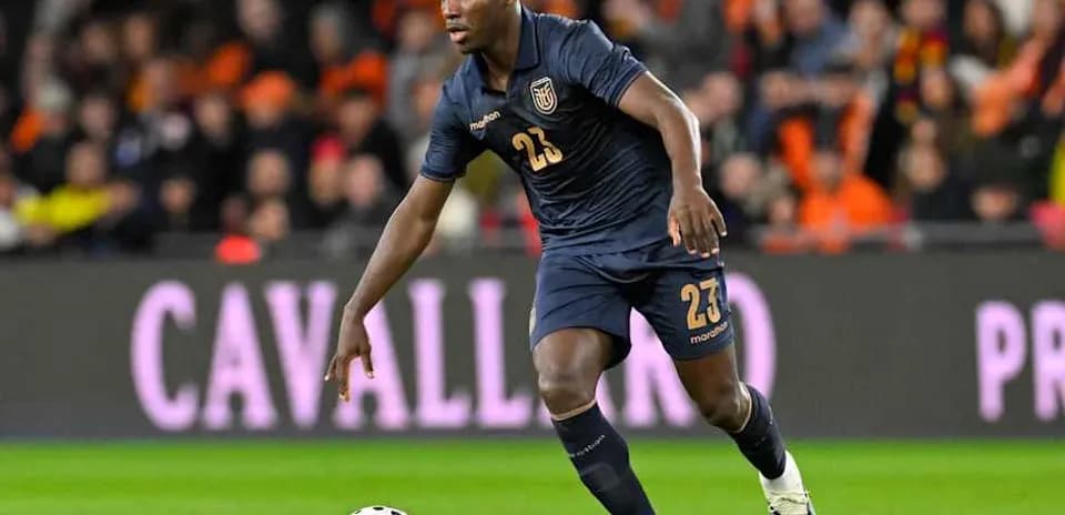 Player in dark jersey dribbling the ball on field