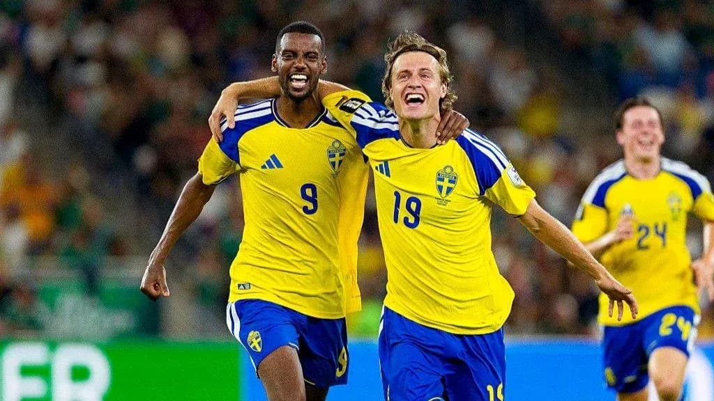 Two Swedish players celebrating a goal during match