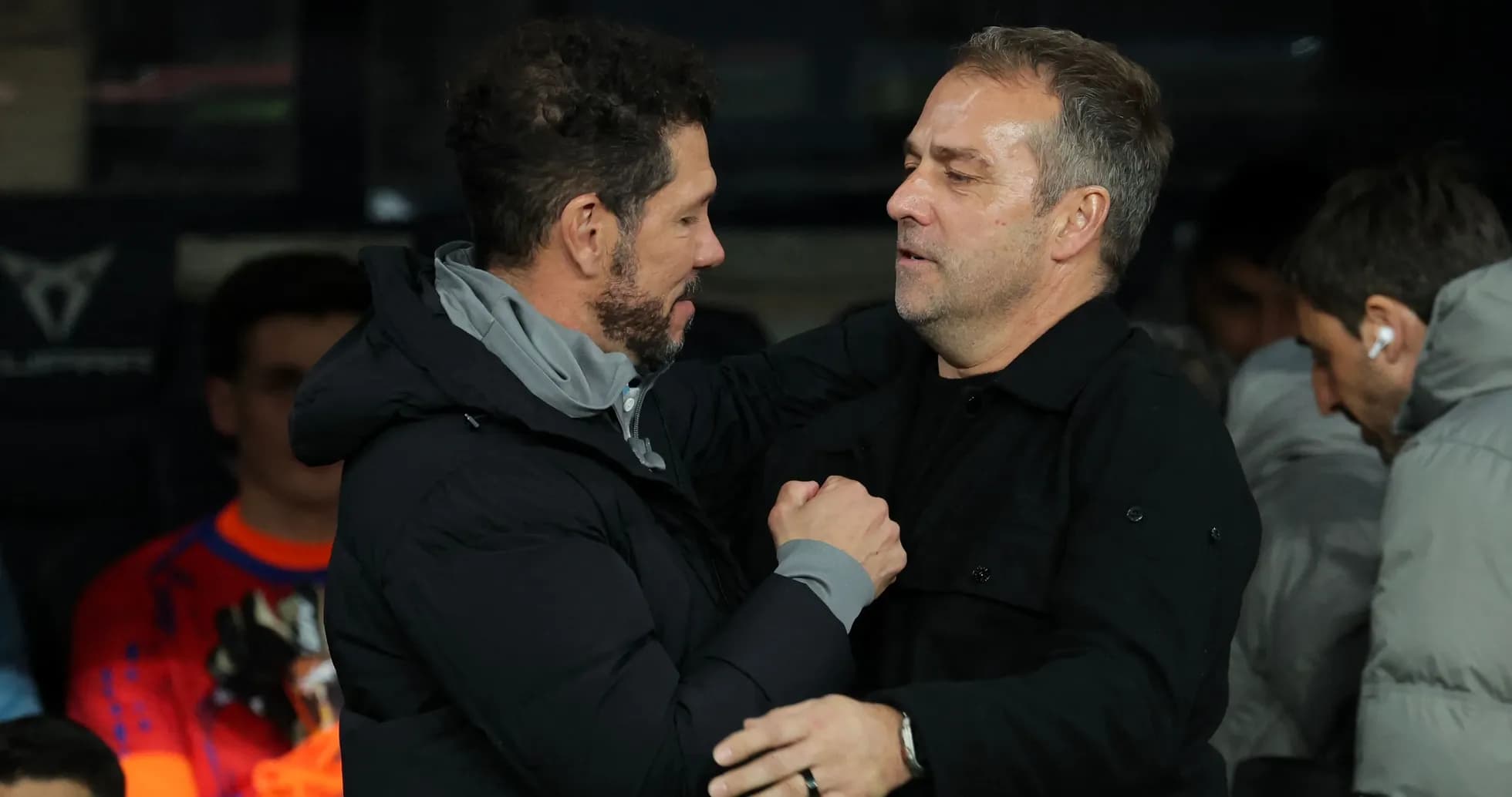 Two coaches greeting each other on the sidelines
