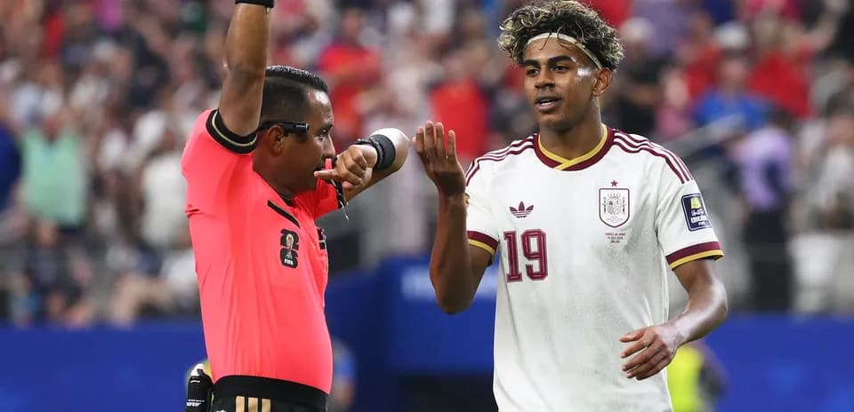 Referee signaling to player during soccer match