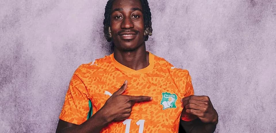 Player pointing to Ivory Coast team logo on jersey