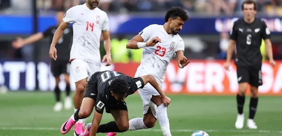 Iran player tackling New Zealand opponent during match