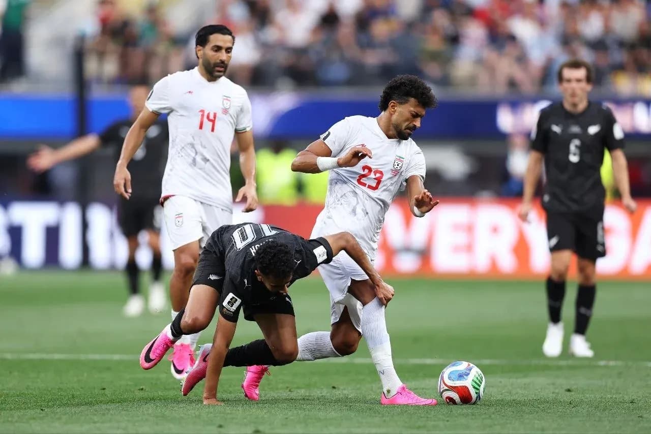 Iran player tackling New Zealand opponent during match