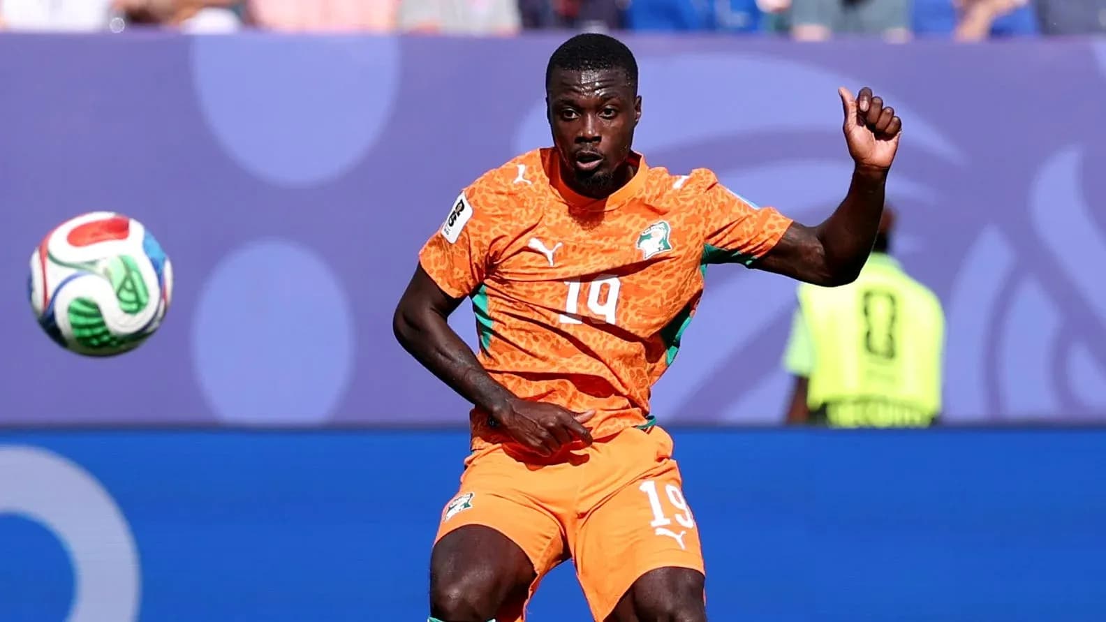 Player in orange jersey controlling the ball during match