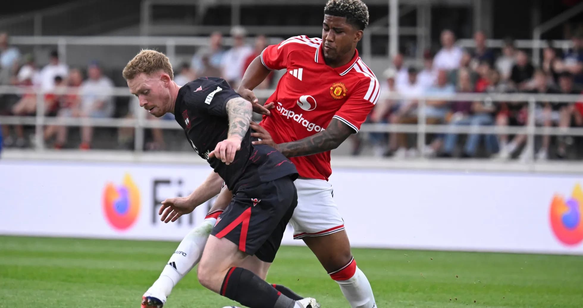Two players battling for the ball on field