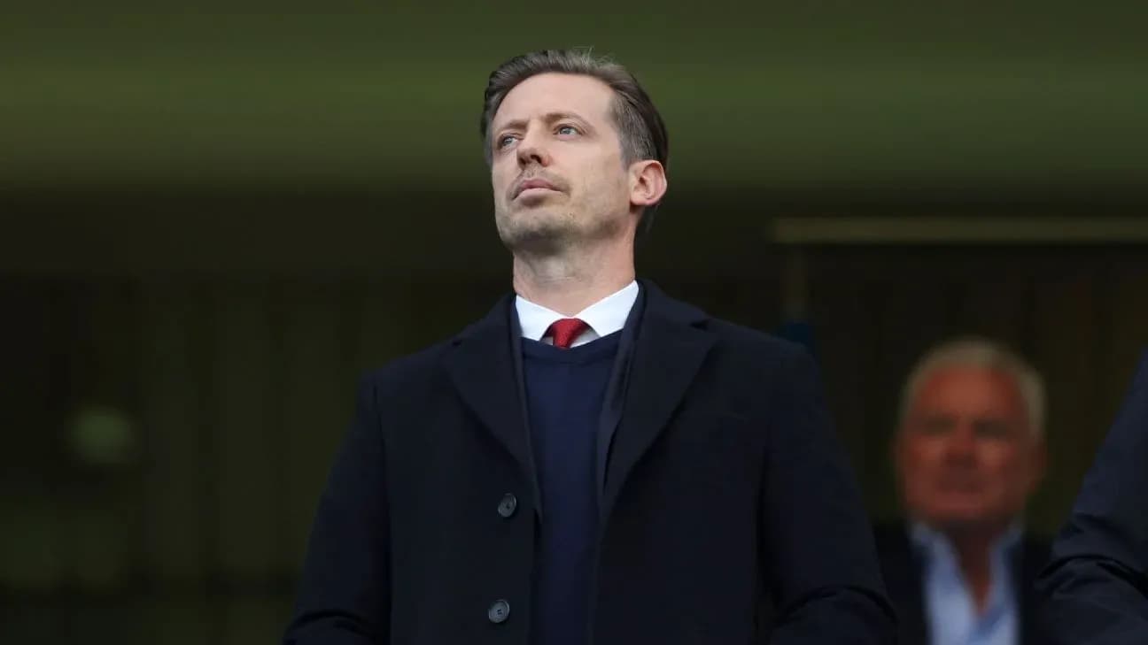 Man in formal attire observing from the stands