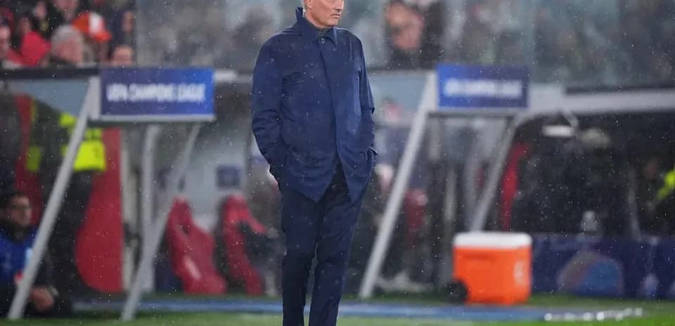 Coach observing match during rainy conditions