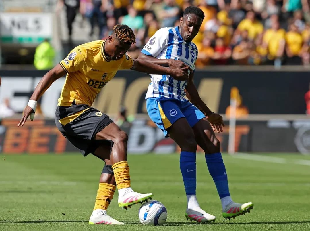 Brighton player challenging Wolves player for the ball