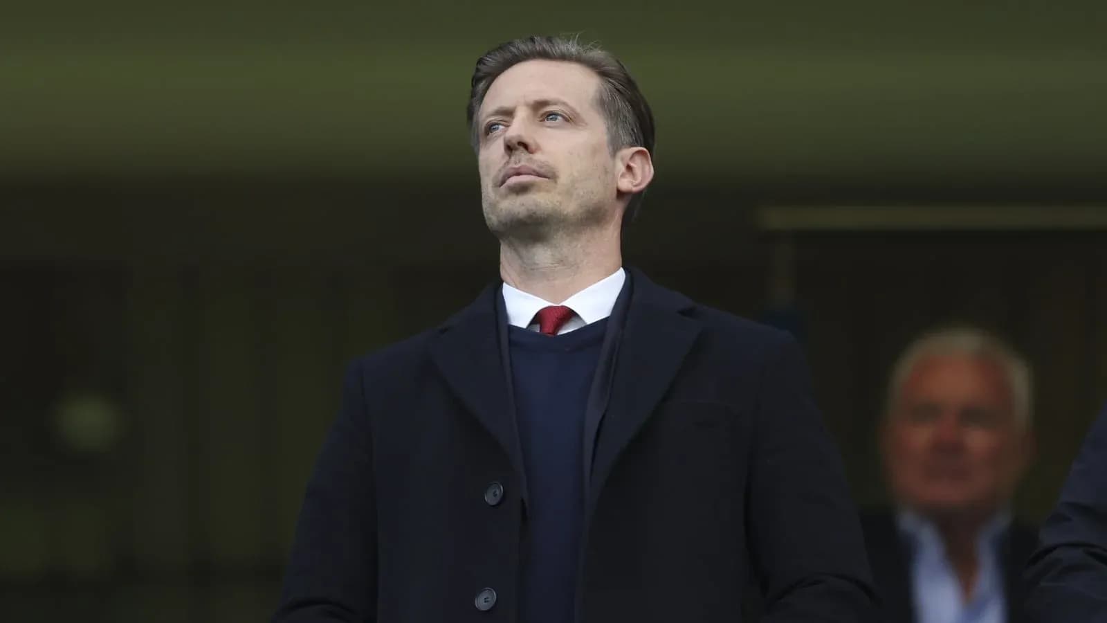 Man in suit observing from the stands