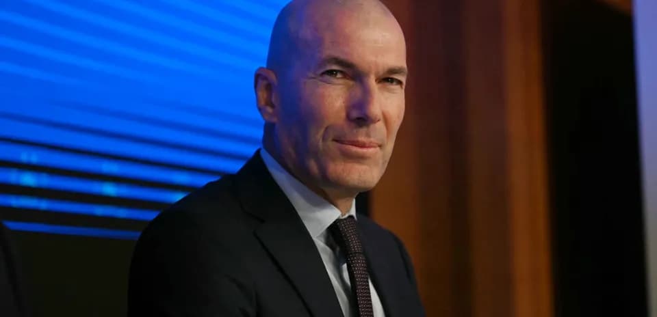 Man in suit seated at a press conference