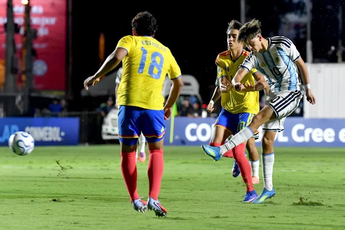 Argentinian player kicking ball past defenders