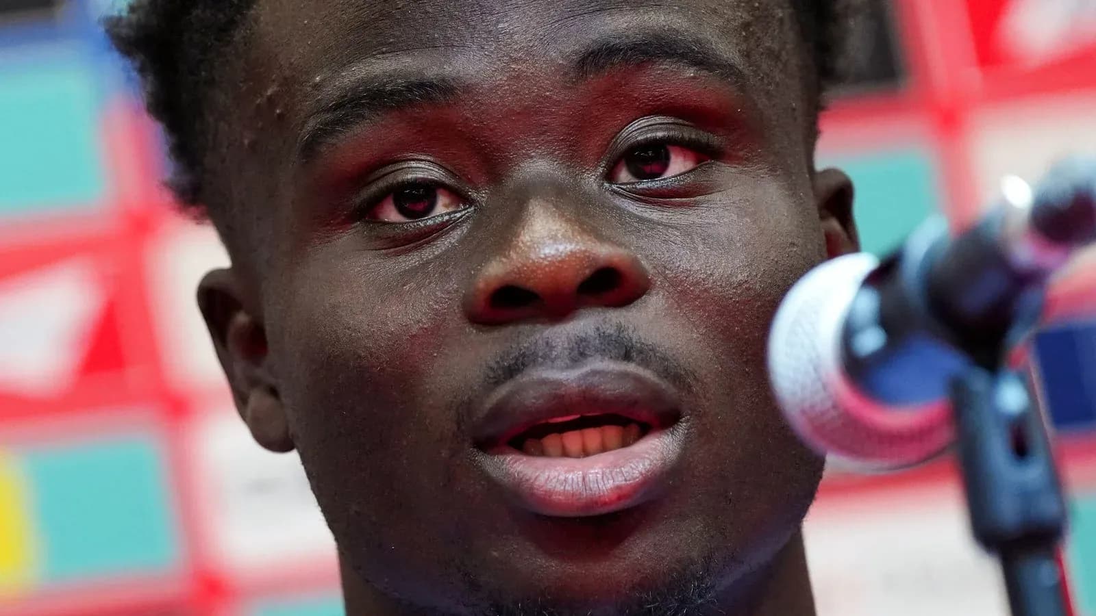 Player speaking at press conference with microphone