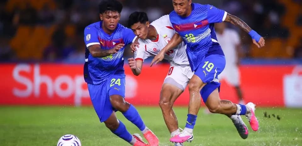 Two defenders challenging an attacker for the ball