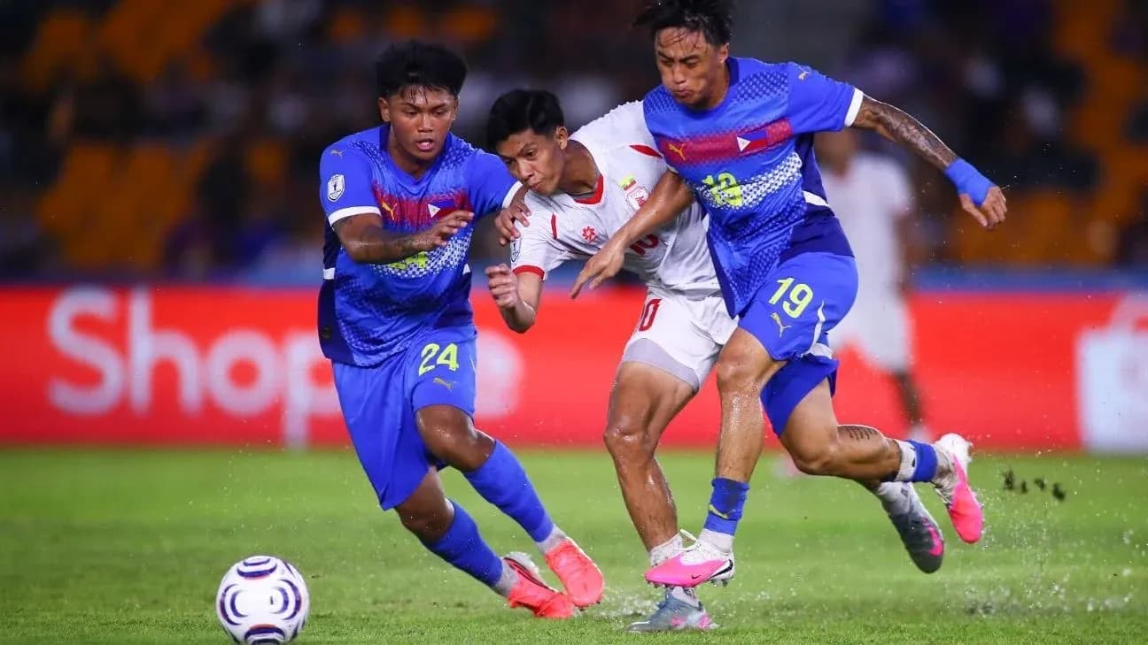 Two defenders challenging an attacker for the ball