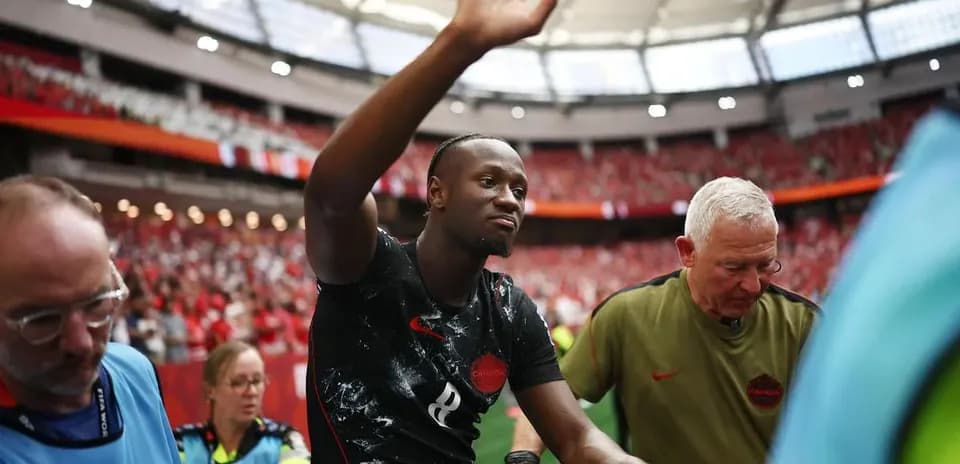 Player waving while being assisted off the field