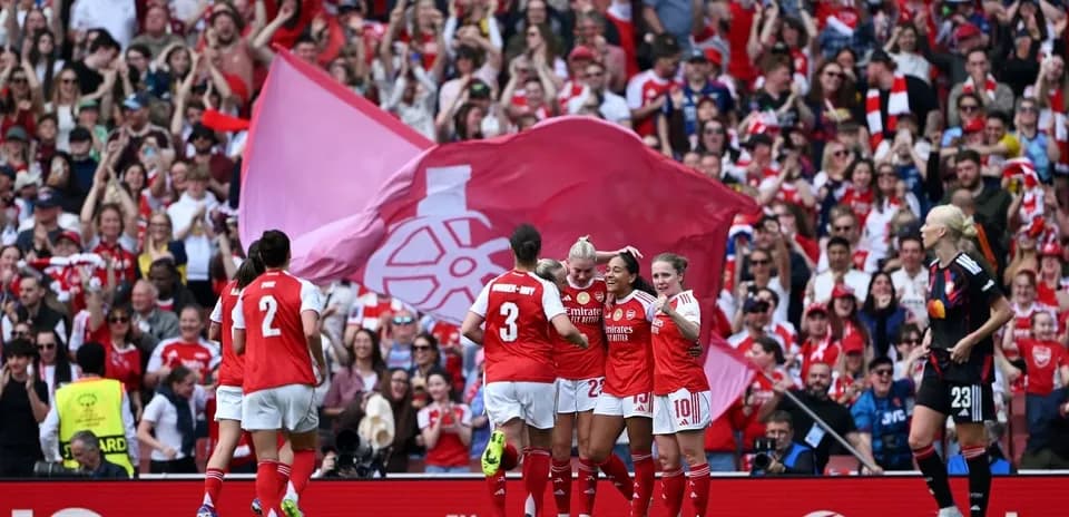 Arsenal women celebrating goal with fans in background