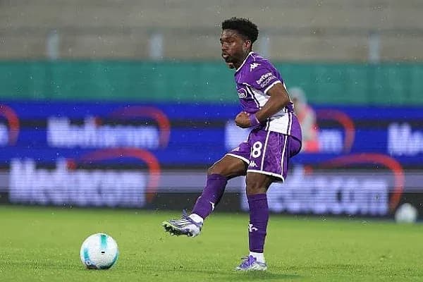 Player in purple kit controlling the ball on field
