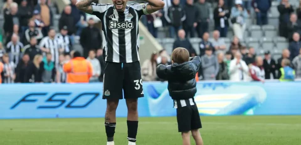 Newcastle player celebrating with young fan on pitch