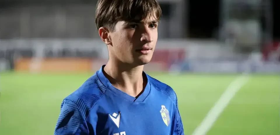 Young player in blue jersey standing on pitch