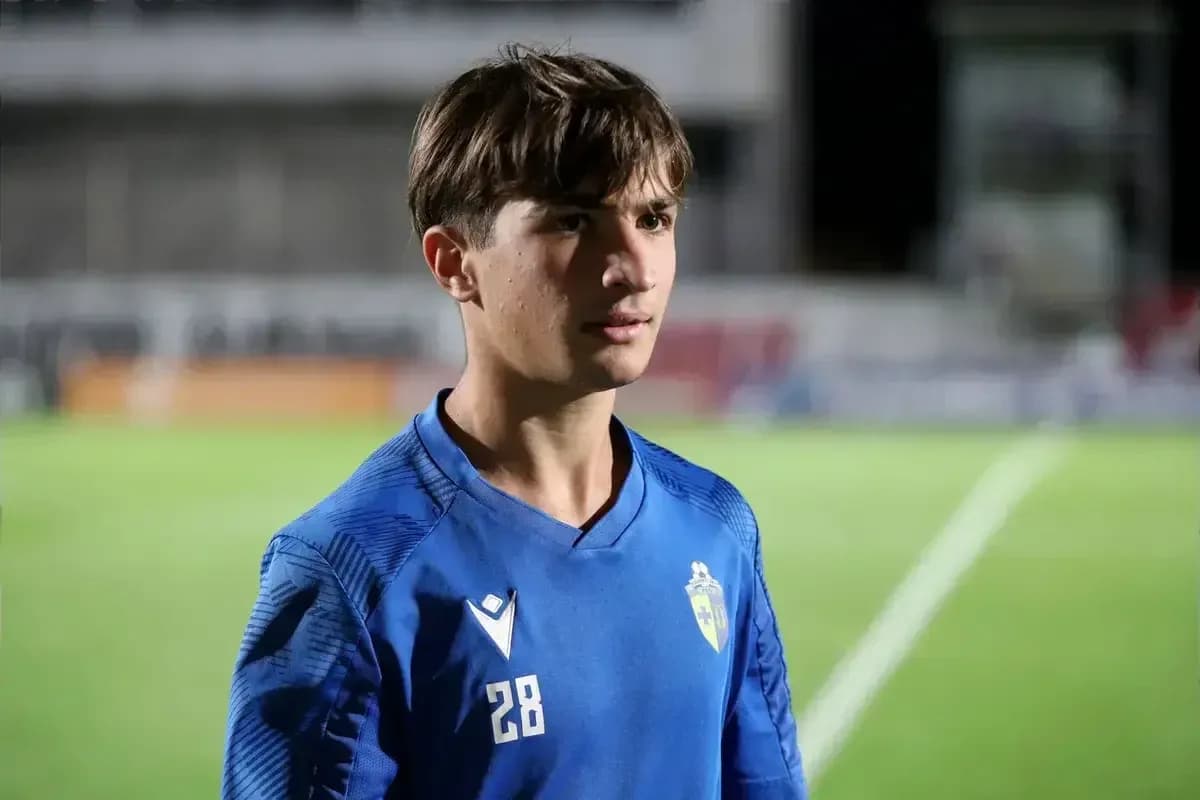 Young player in blue jersey standing on pitch