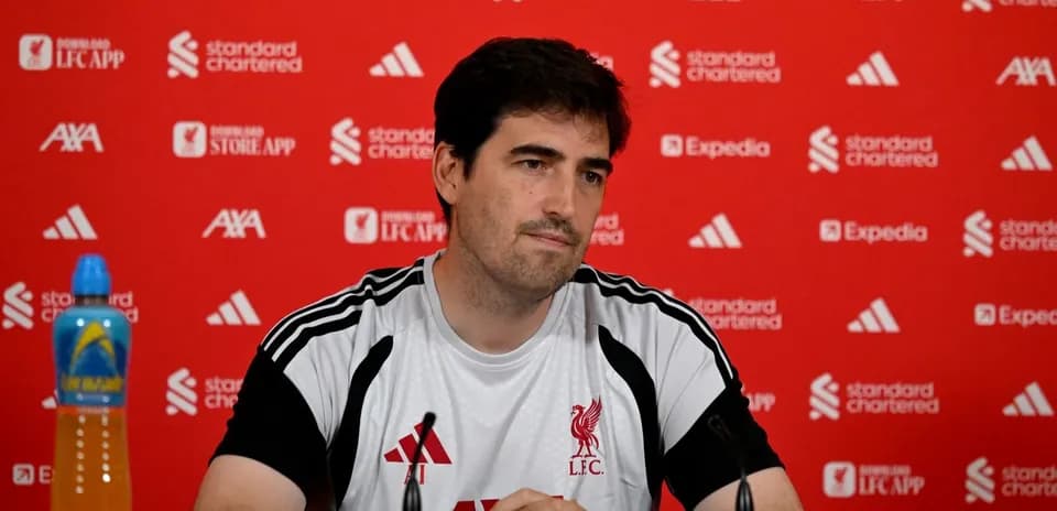 Coach at Liverpool FC press conference with backdrop