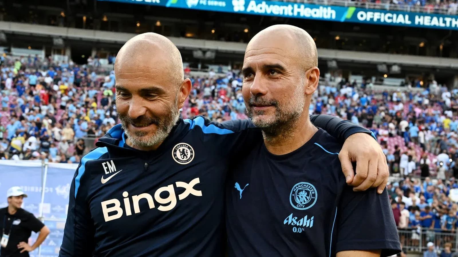 Two football coaches smiling together after a match