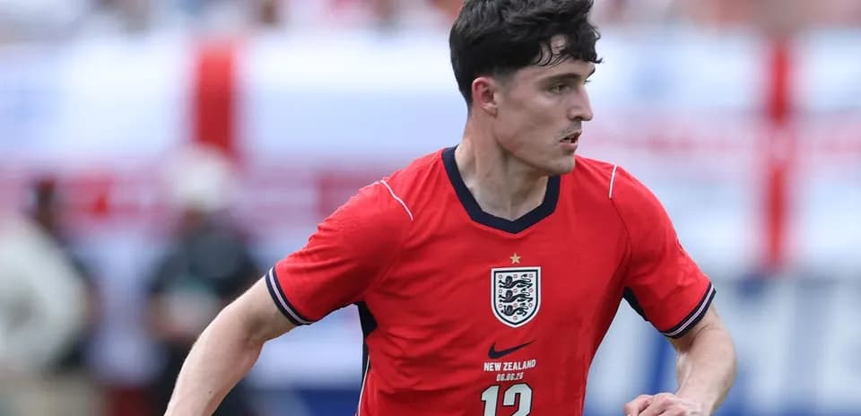 Player in red England jersey running during match