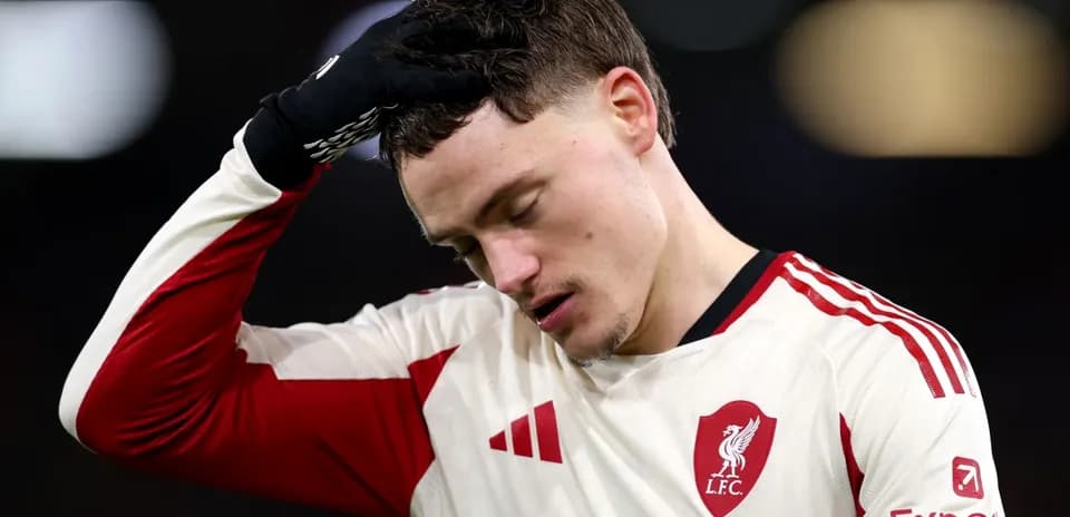 Player in Liverpool kit with hand on forehead