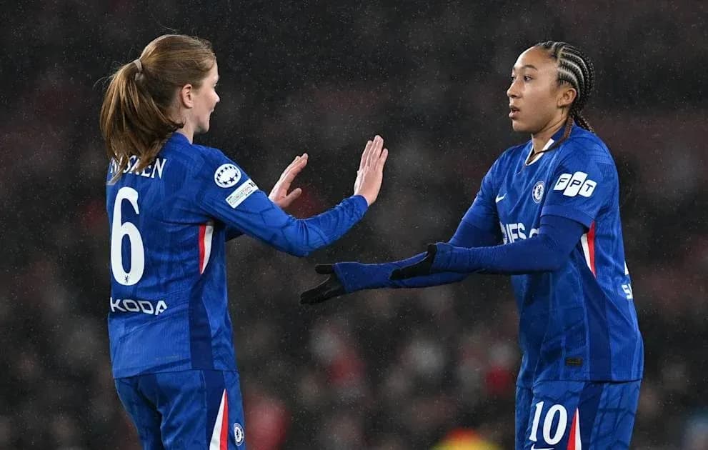 Two Chelsea players exchanging a handshake on field