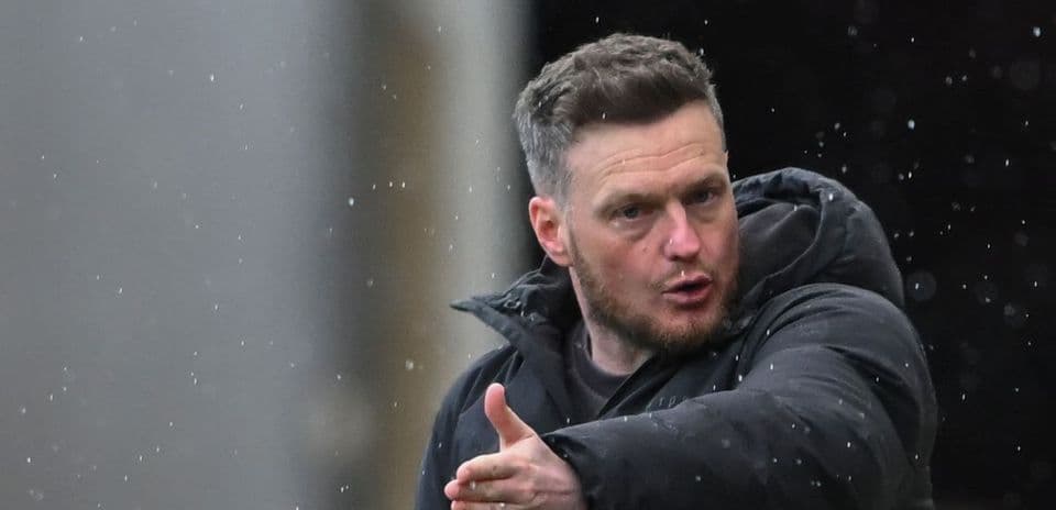 Coach gesturing during a rainy match