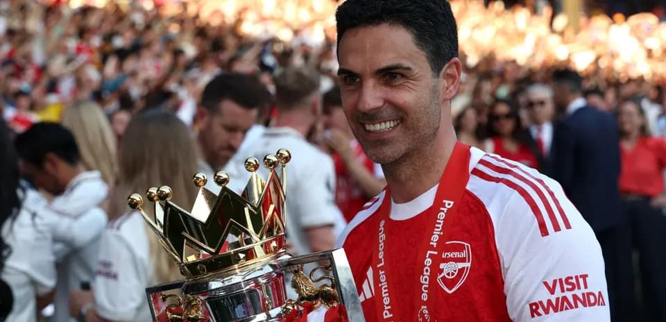 Arsenal manager holding Premier League trophy at celebration