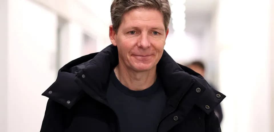 Man walking in corridor wearing a black jacket
