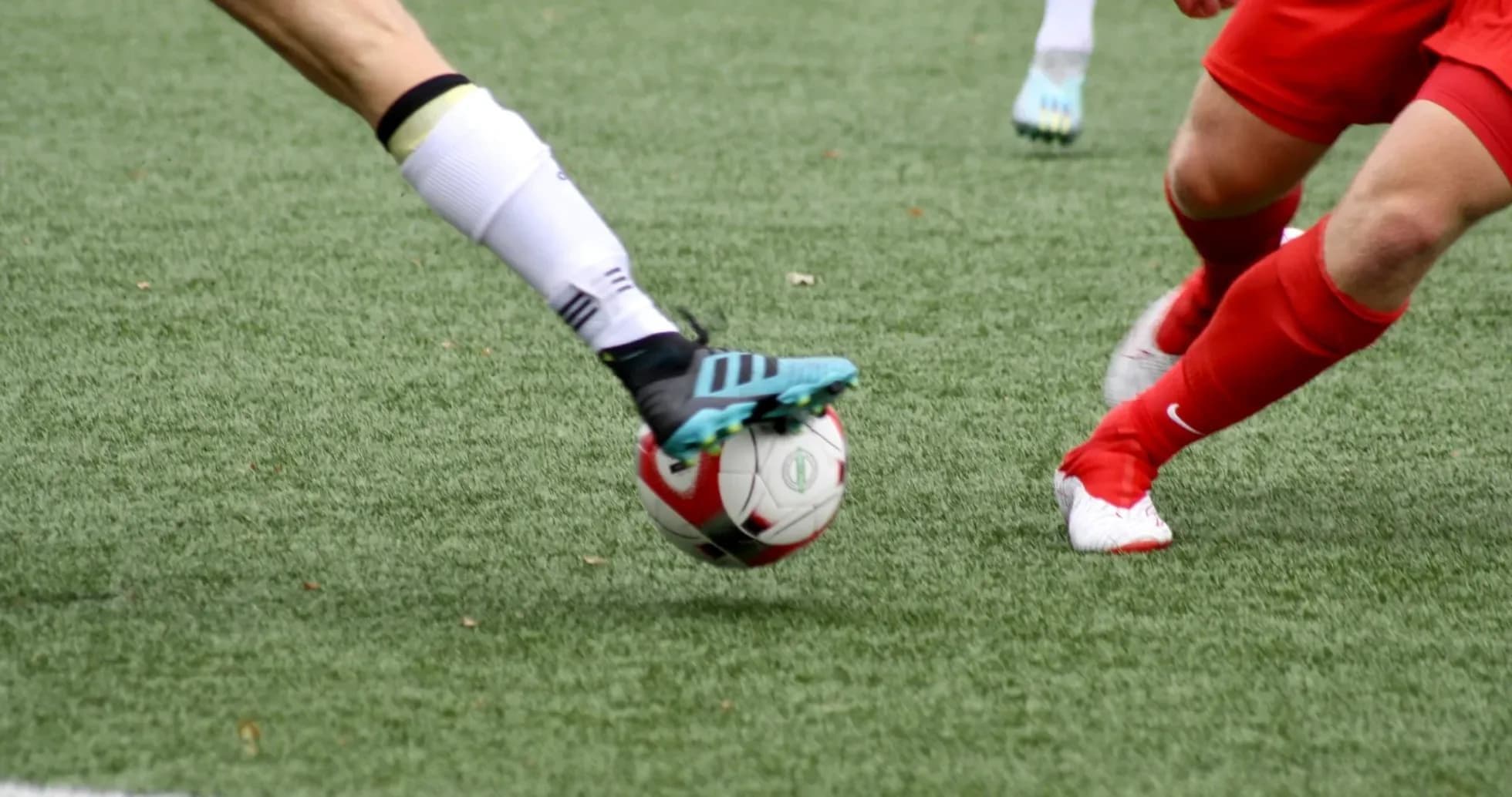 Two players competing for the ball in football