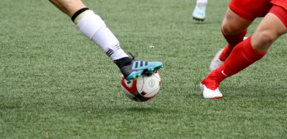 Two players competing for the ball in football