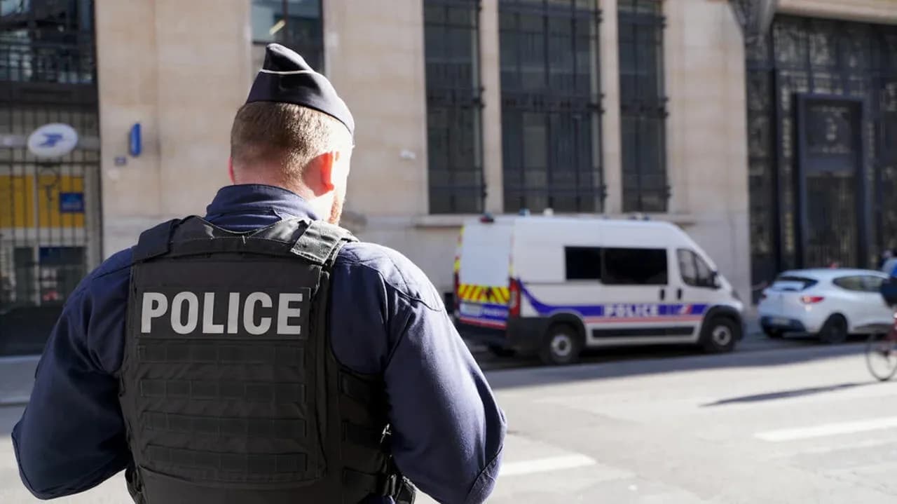 Police officer observing street with police van nearby