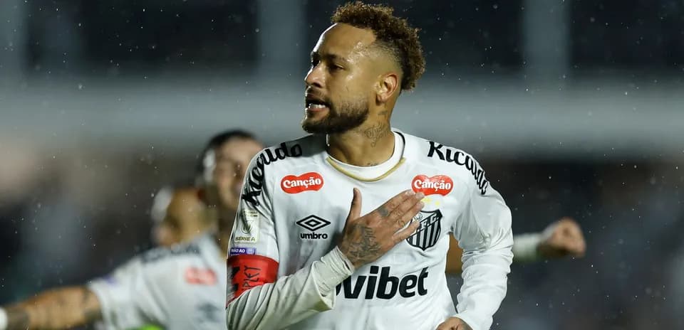 Player celebrating a goal in a rainy match
