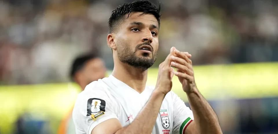 Player applauding fans during a football match